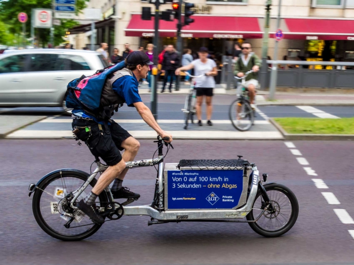 Fahrradkurier auf einem Lastenfahrrad in Berlin